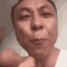 A man on a webcam taking a long drag on a cigarette without changing expression.